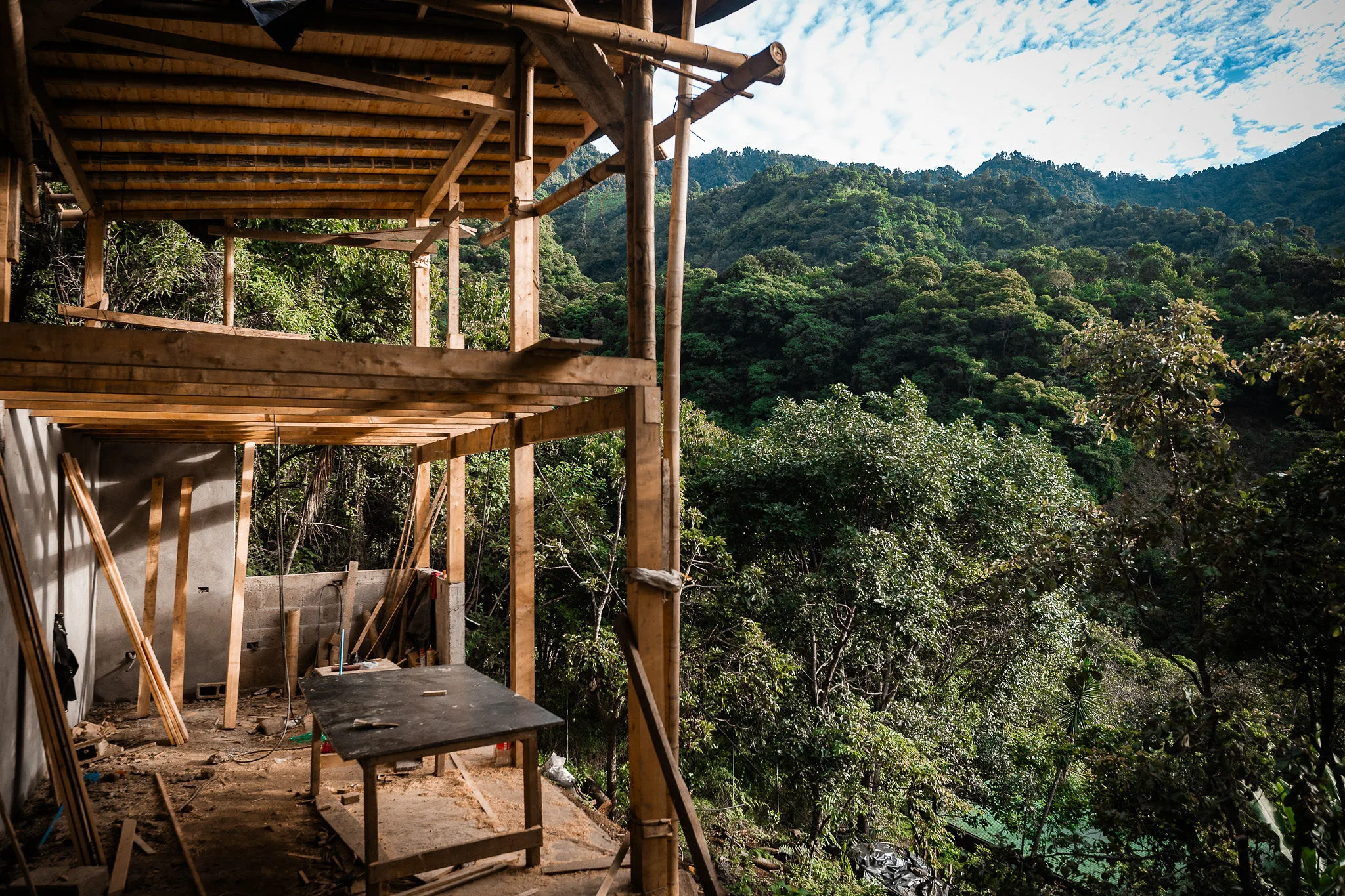 Three people working through the WuWei Village masterplan at a laptop inside Casa Orquídea.